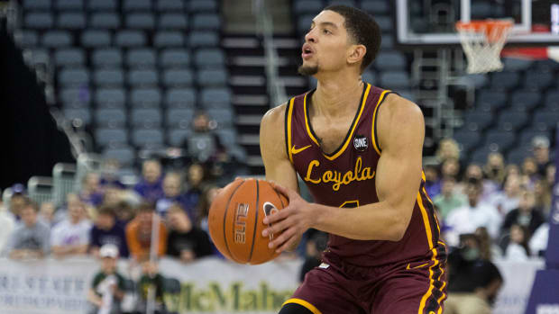 Loyola Chicago s Lucas Williamson (1) takes a three-point shot as the Loyola Chicago Ramblers play the University of Evansville Purple Aces.